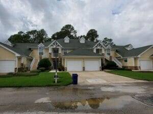 A professional pressure washer cleaning a concrete driveway, showcasing hot water pressure washing benefits in Jacksonville,