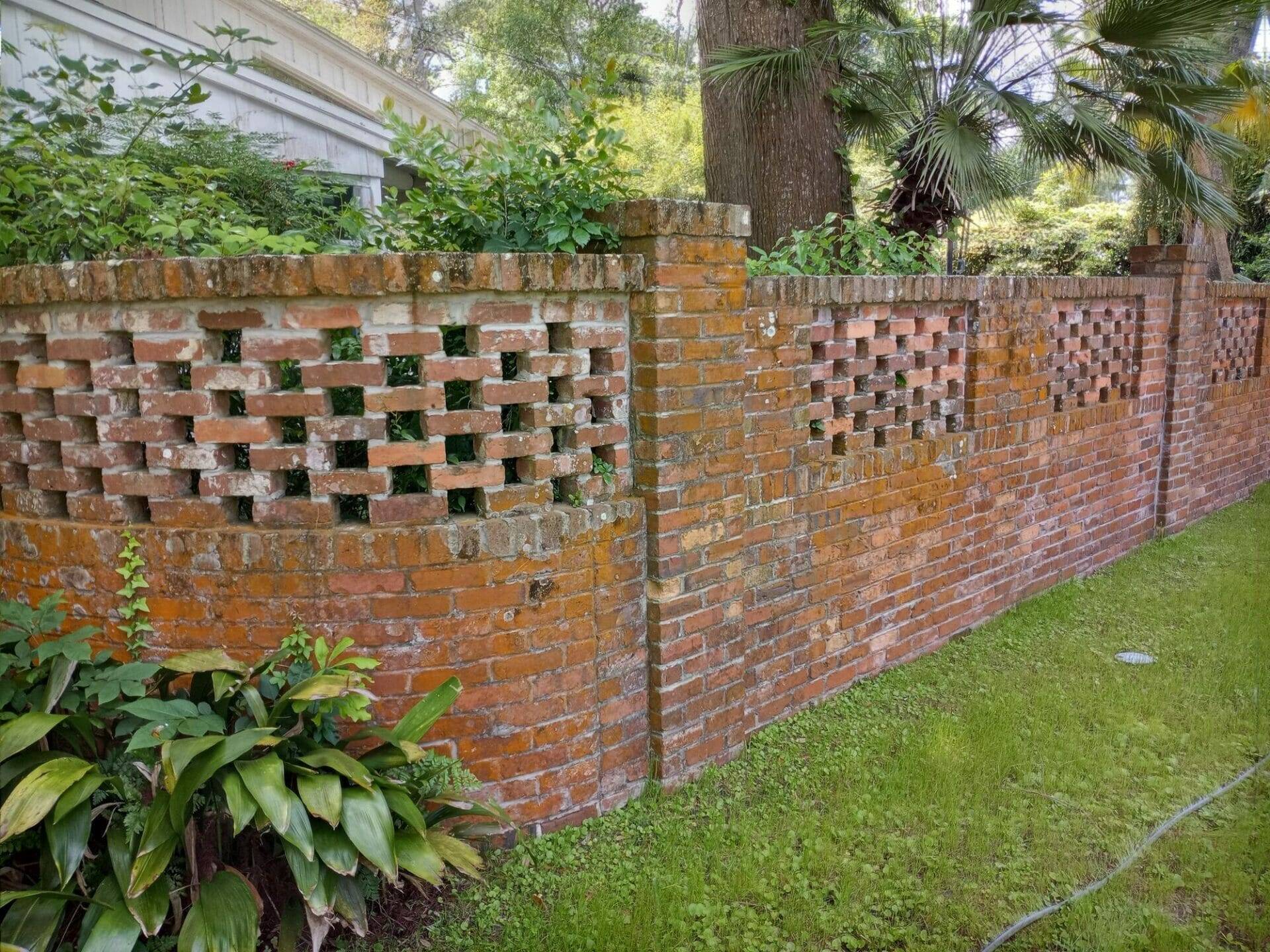 Brick house fence before being cleaned by Hydro-Kleen Pressure Washing team