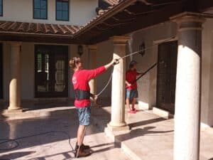 A pressure washing service in action, cleaning a driveway with a high-pressure water spray.